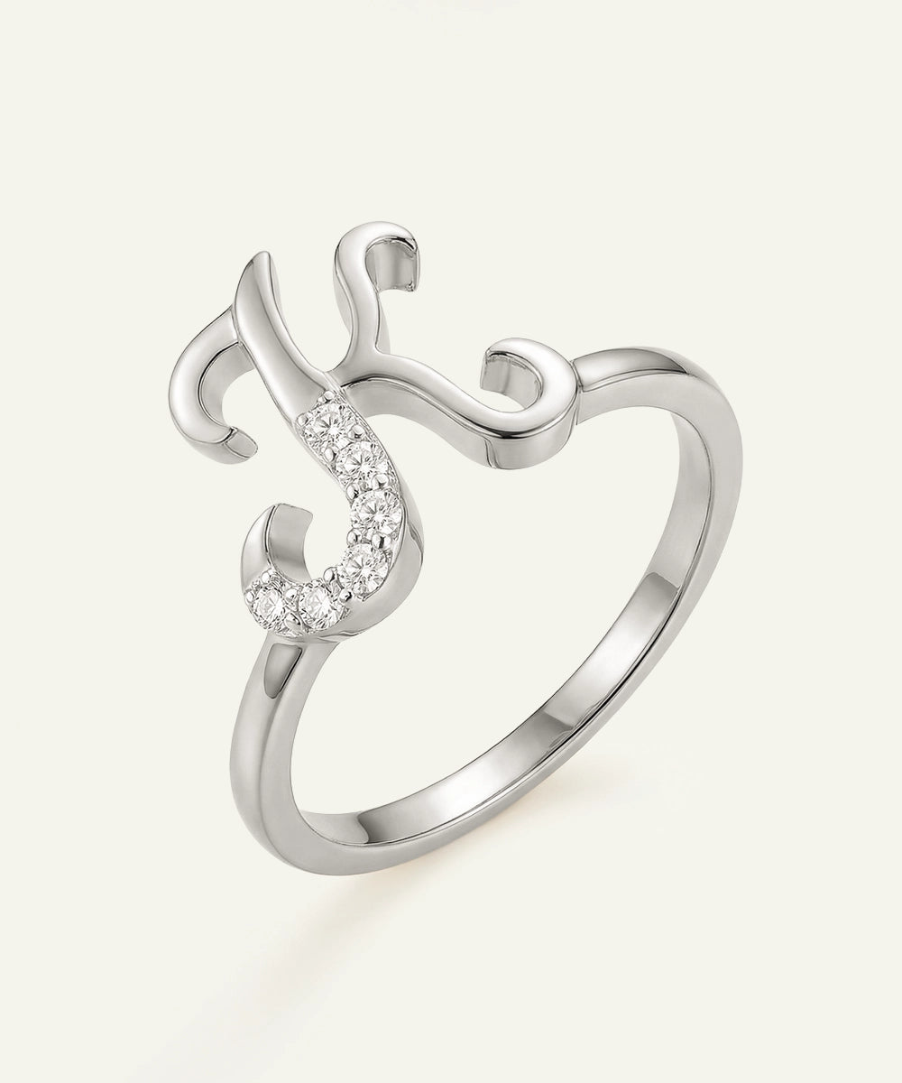 Silver ring with a curved design and small gemstones on a white background