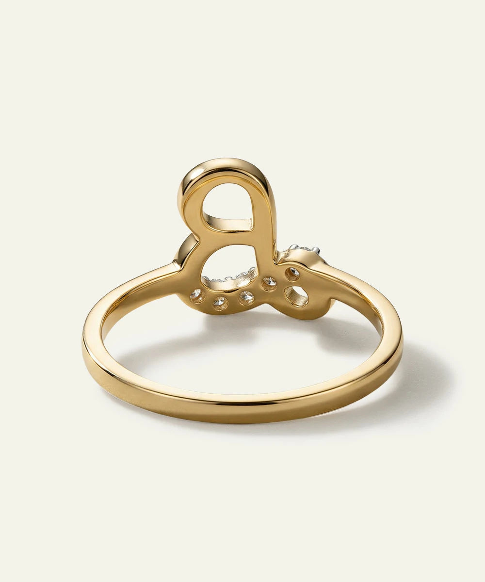 Gold ring with a unique design on a light beige background