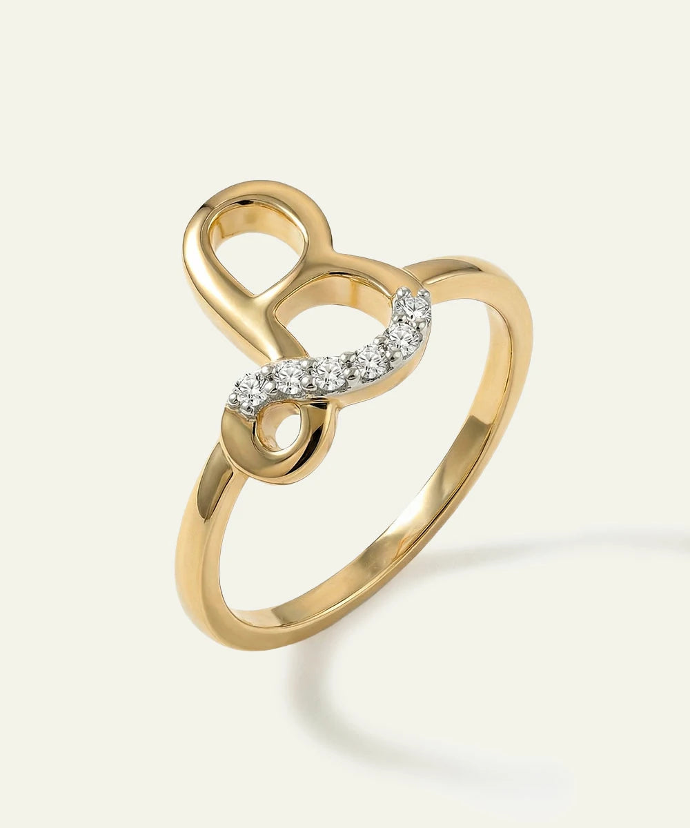 Gold ring with heart design and small diamonds on a light background
