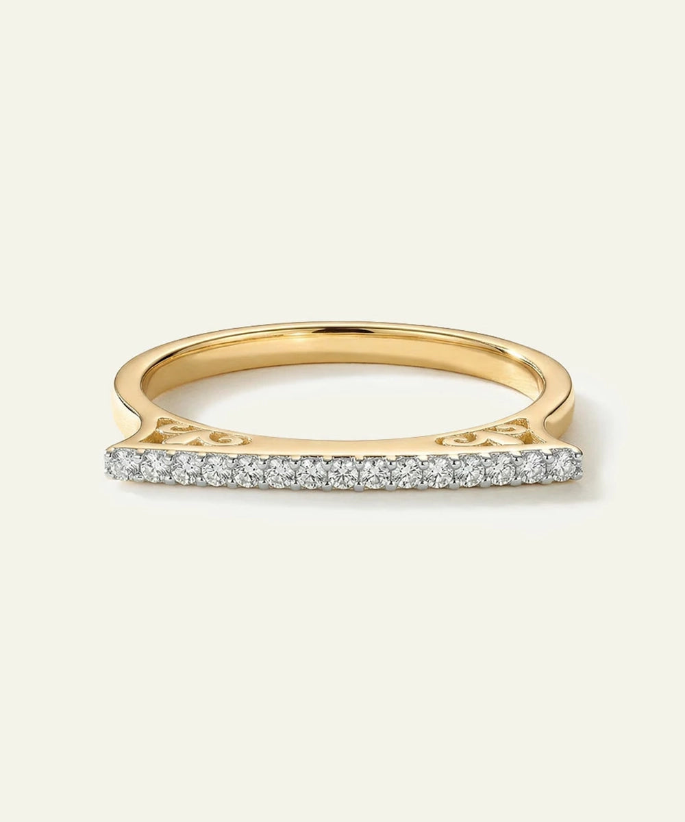 Gold ring with small diamonds on a light beige background