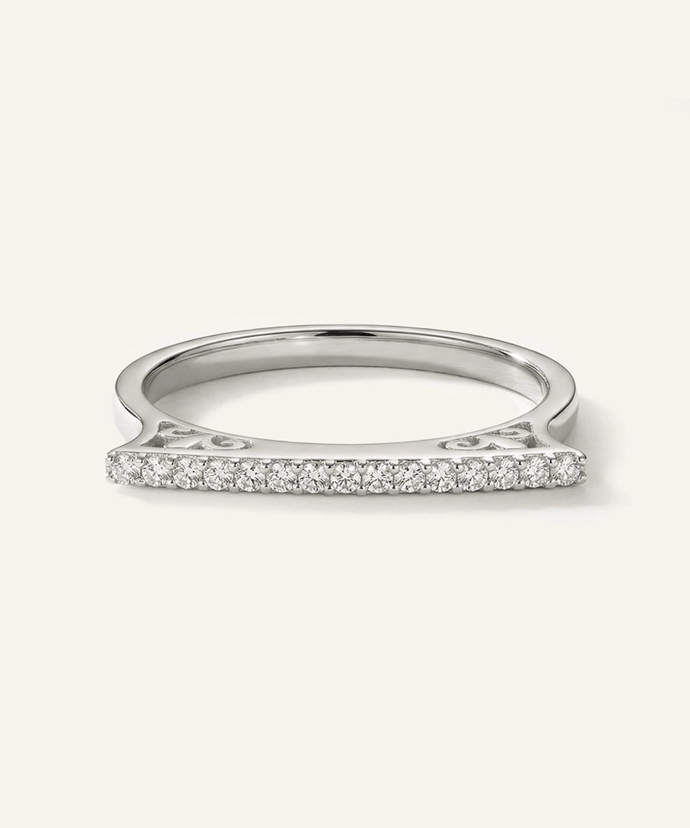 Silver ring with small diamonds on a light gray background