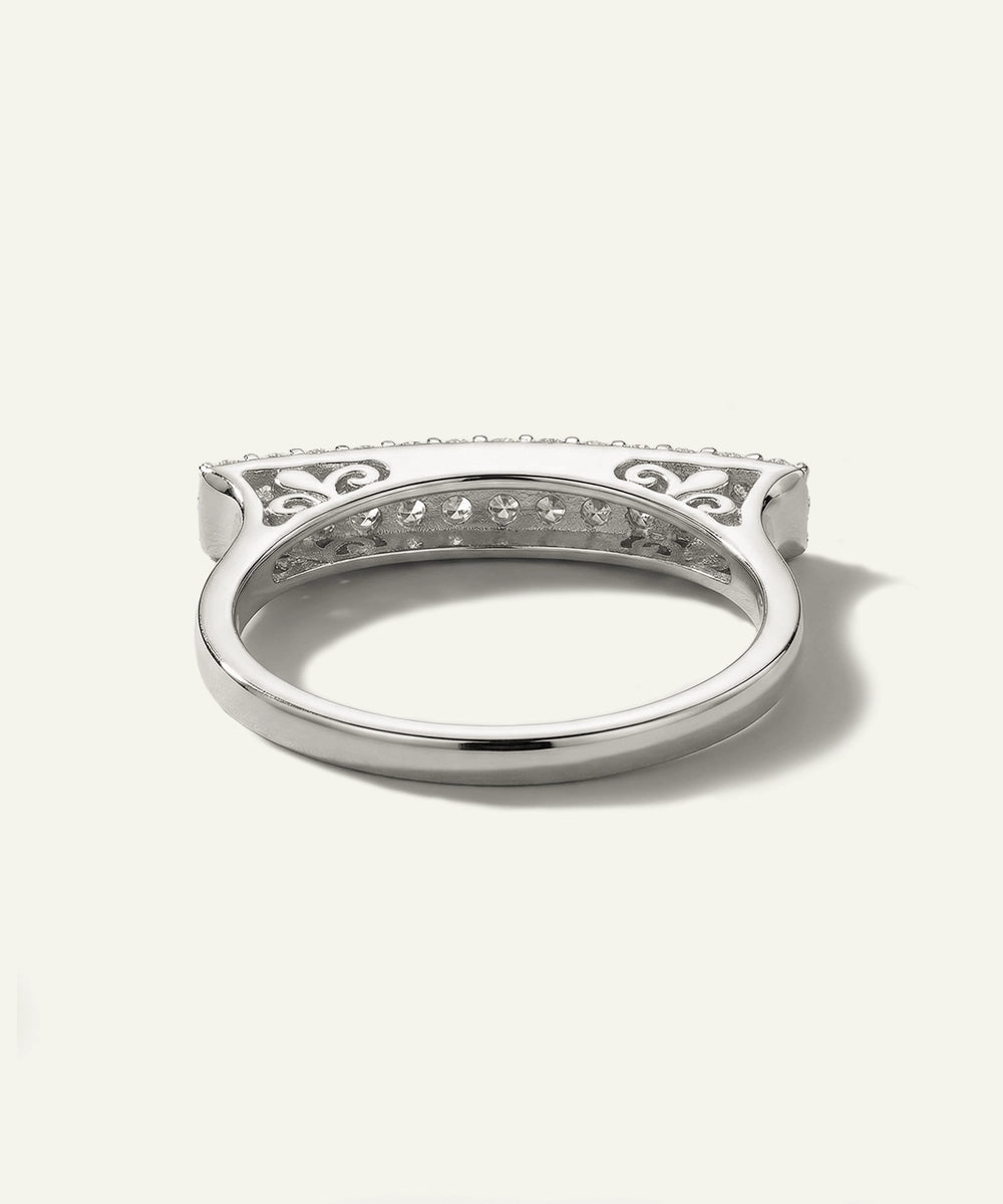 Silver ring with intricate design on a white background