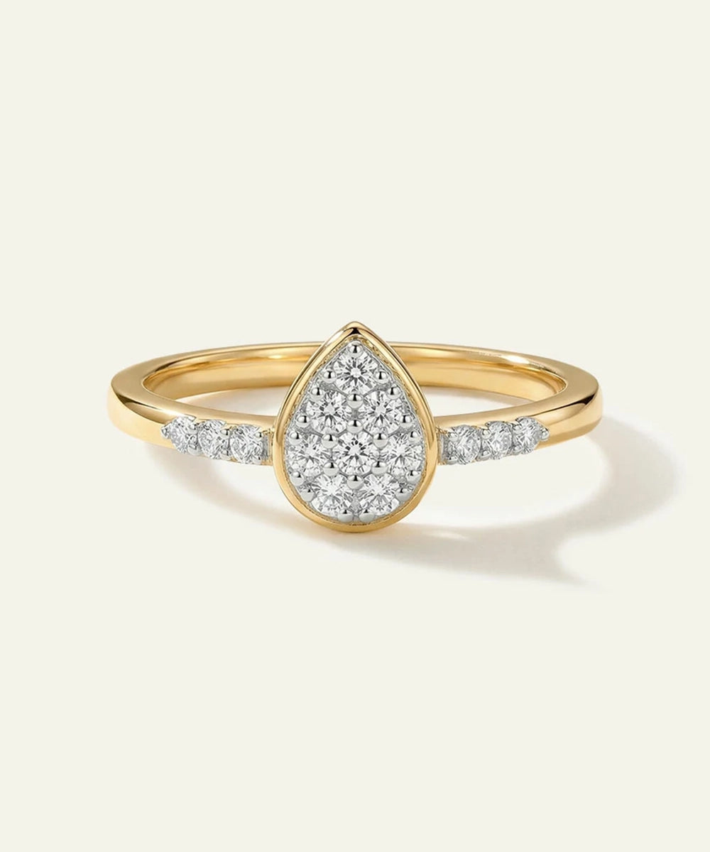 Gold ring with a teardrop-shaped diamond design on a white background