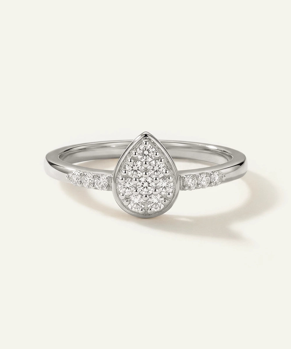 Silver ring with a teardrop-shaped diamond on a light gray background