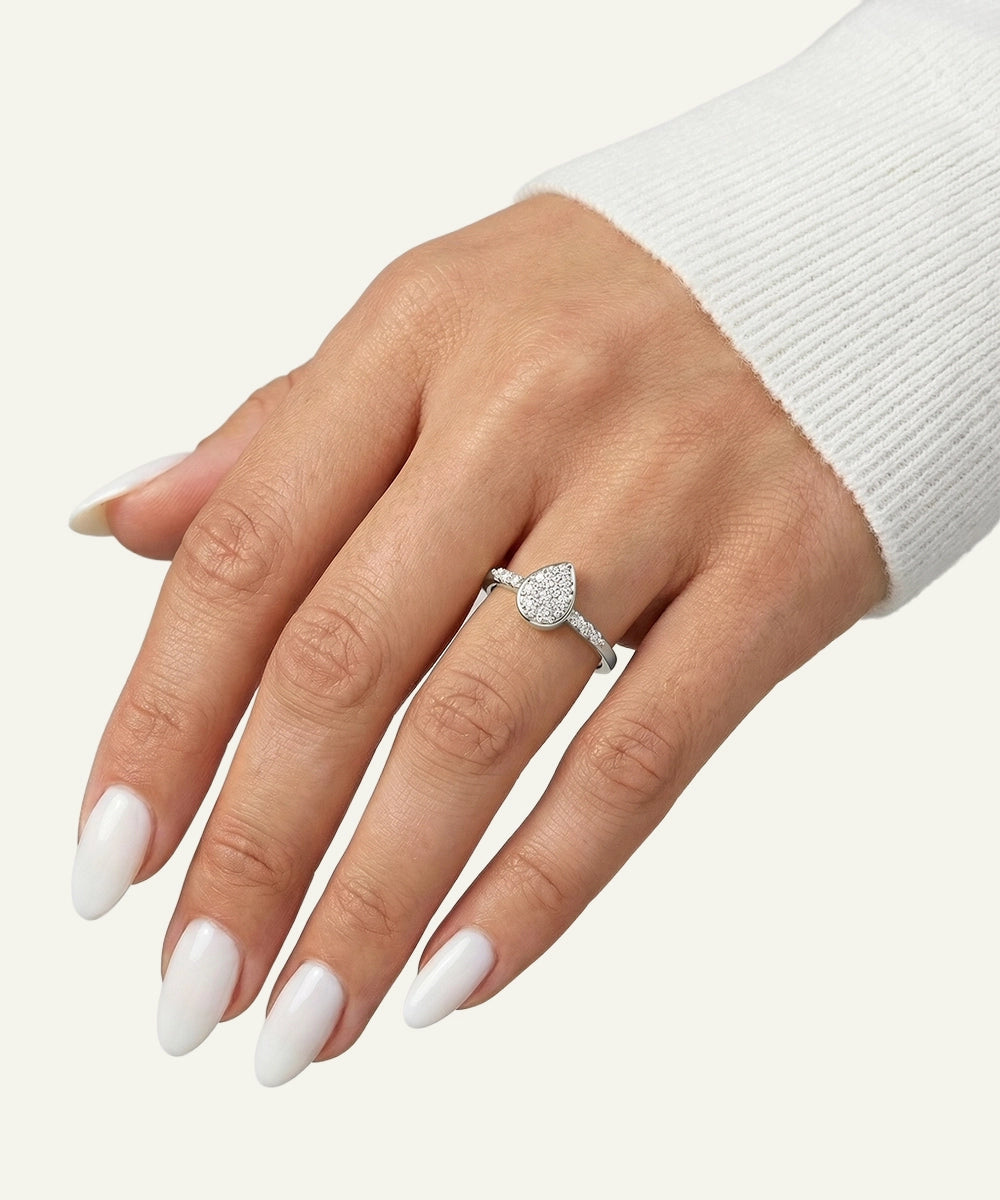 Hand wearing a silver ring with a diamond on a white background