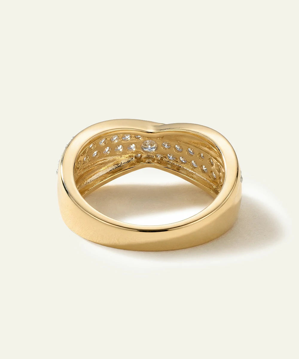 Gold ring with diamond accents on a light beige background