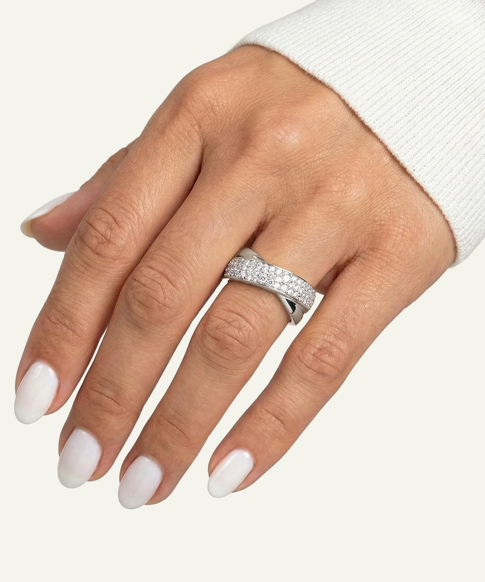 Hand wearing a silver ring with a white background