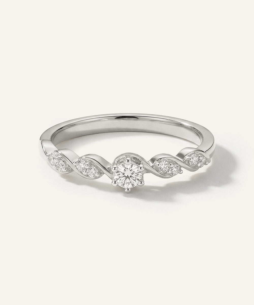 Silver ring with diamond accents on a light gray background
