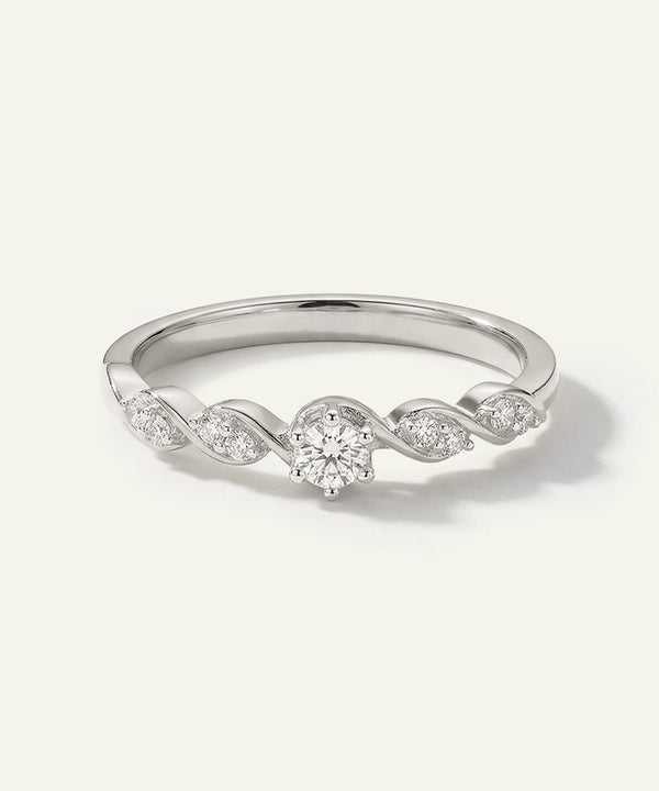 Silver ring with diamond accents on a light gray background