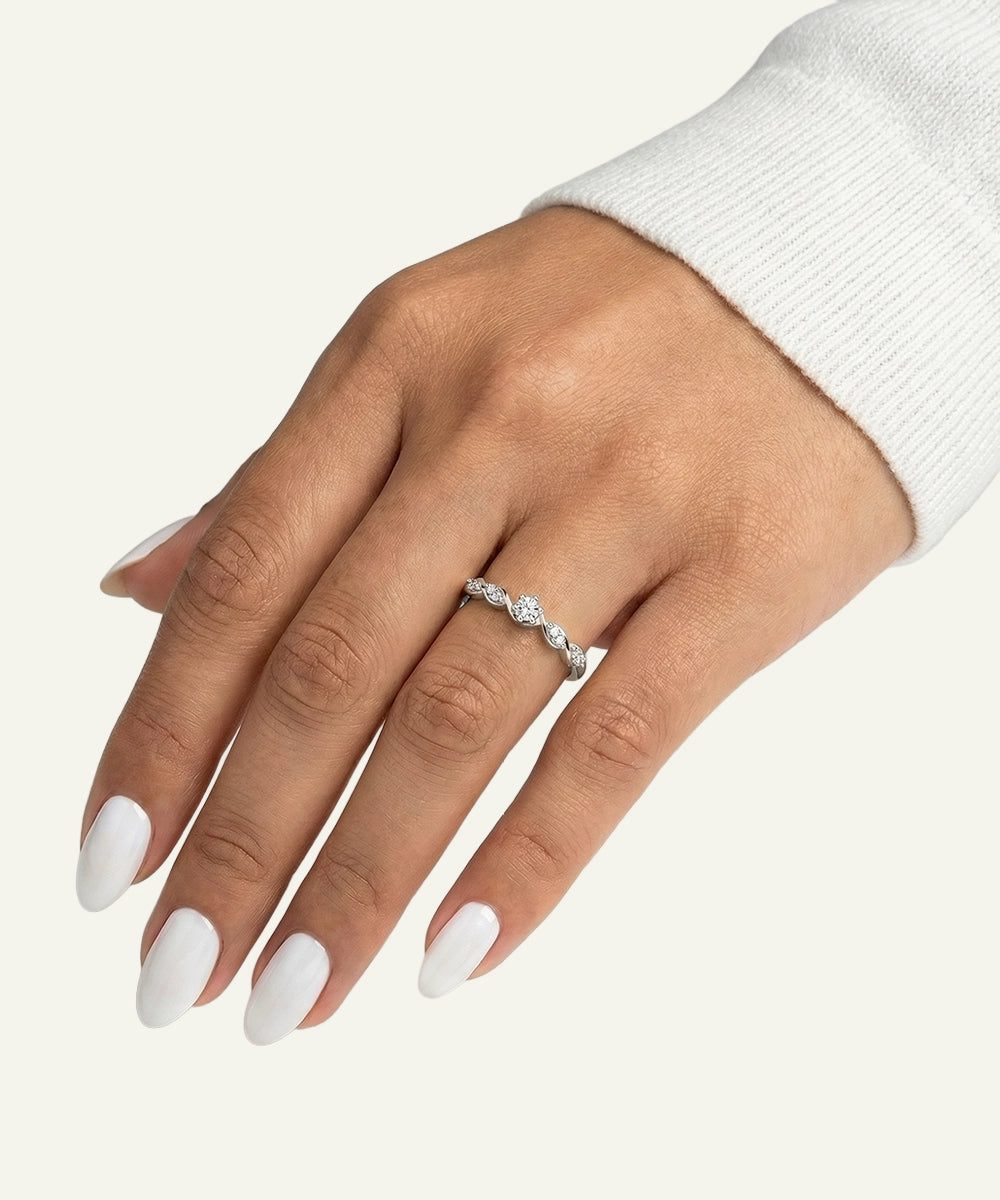 Hand wearing a silver ring with a diamond on a white background