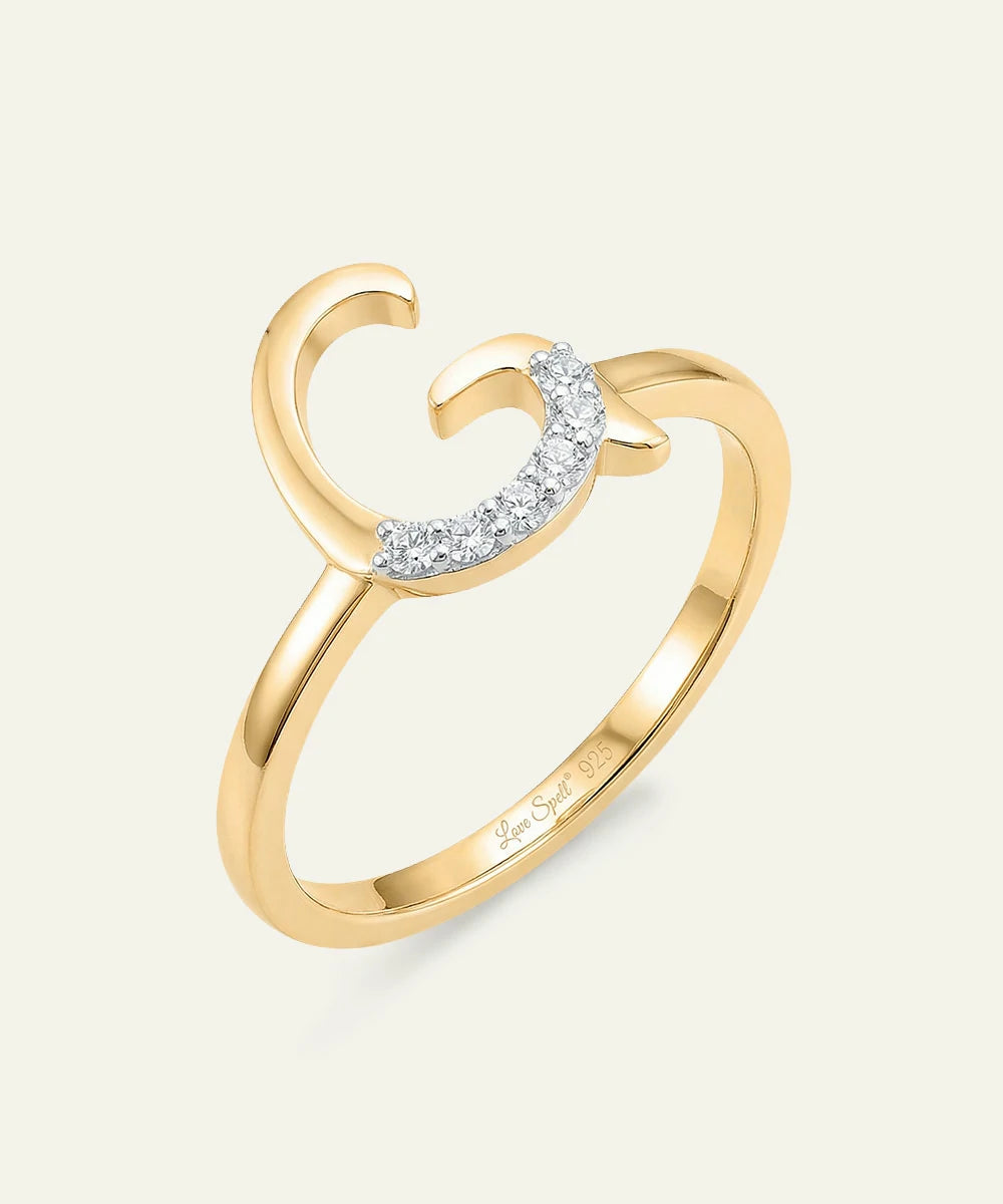 Gold ring with a crescent moon design on a light gray background