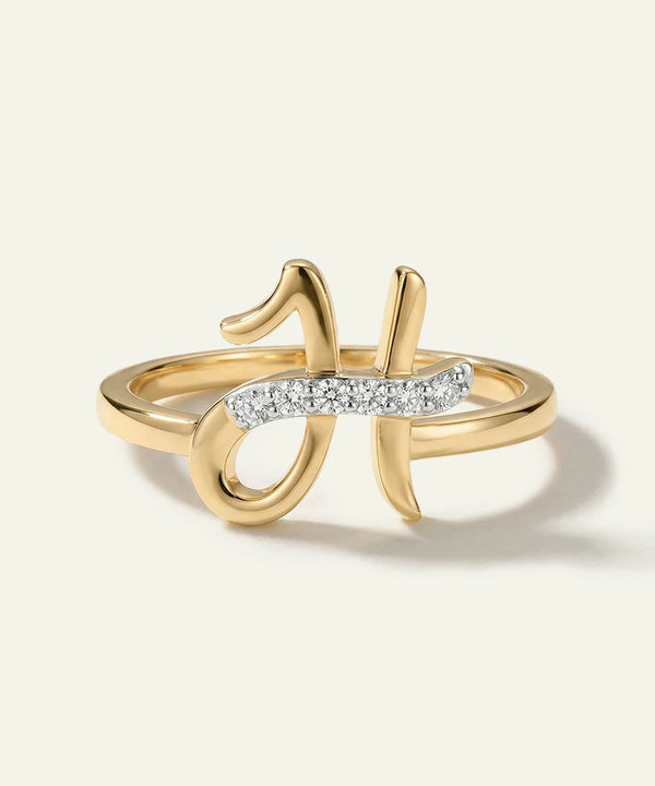 Gold ring with diamond accents on a light beige background