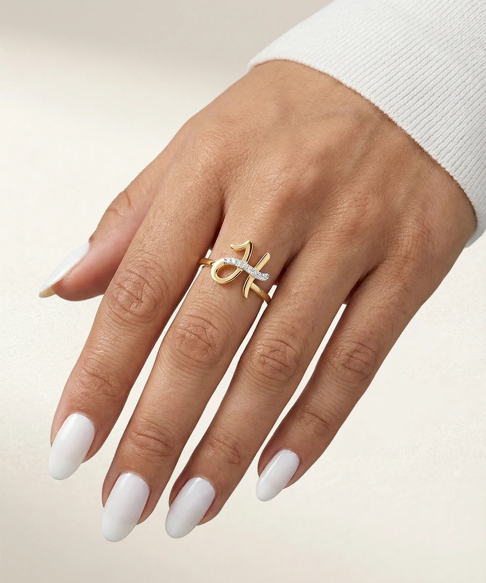 Hand wearing a gold ring with a diamond on a neutral background