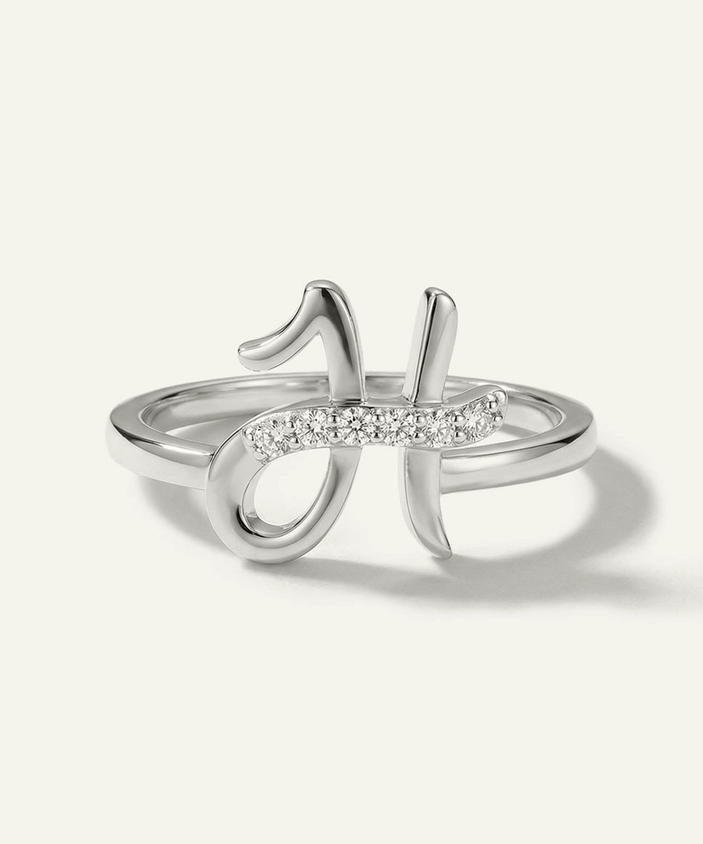 Silver ring with diamond accents on a light gray background