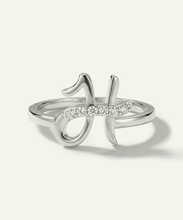 Silver ring with diamond accents on a light gray background