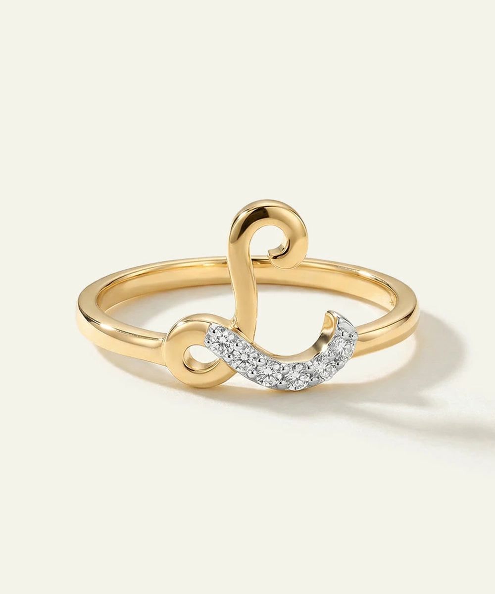 Gold ring with a heart and diamond design on a light background