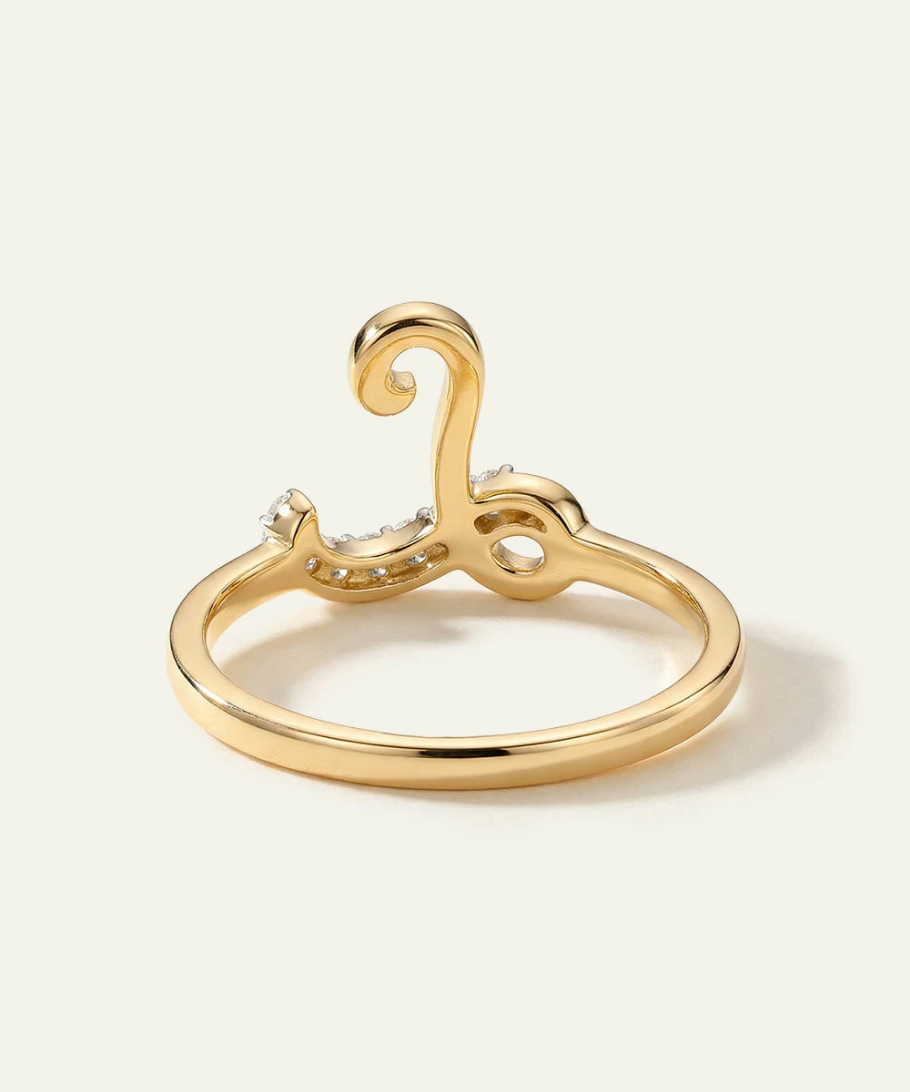 Gold ring with intricate design on a light beige background