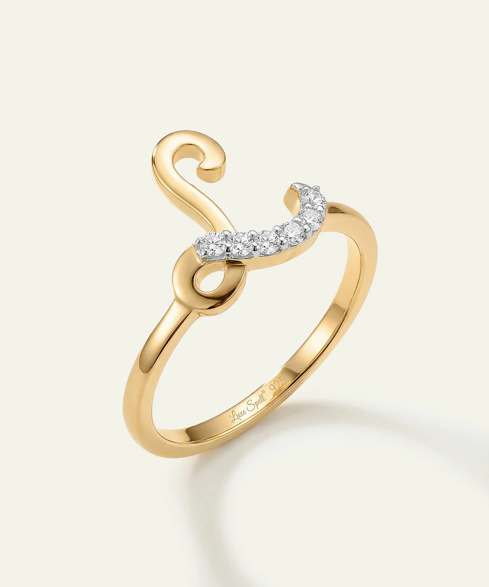 Gold ring with a crescent moon design on a light beige background
