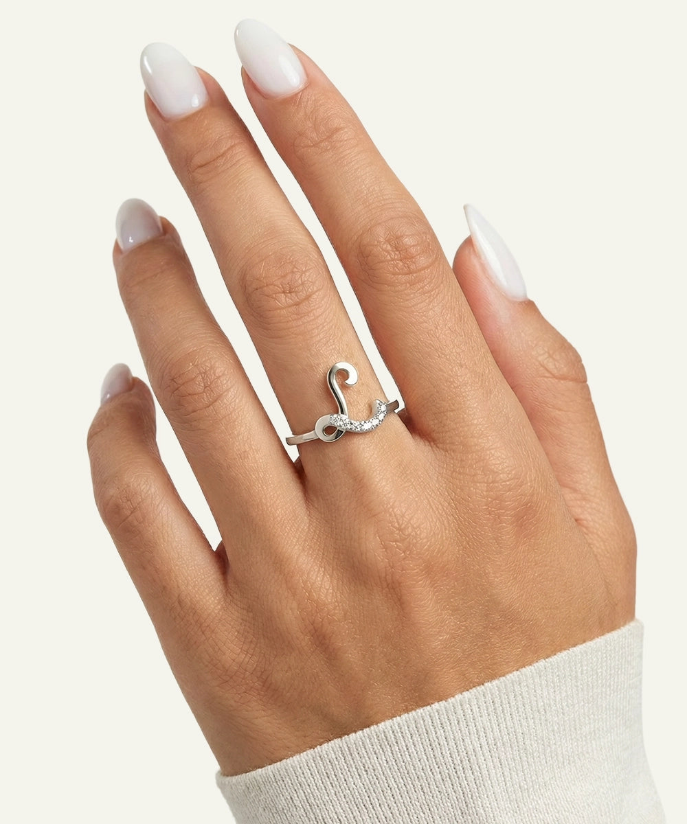 Silver ring with a unique design on a hand against a neutral background