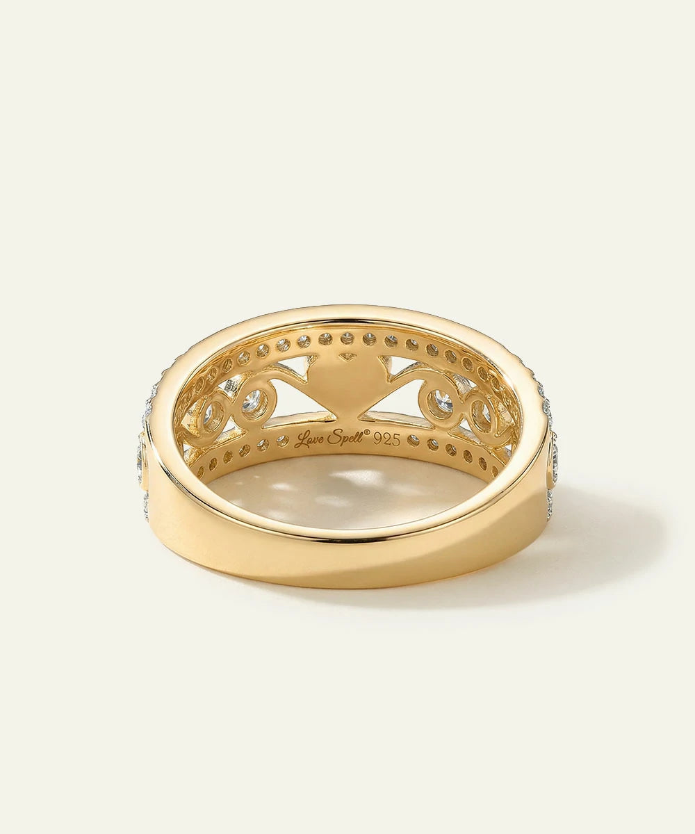 Gold ring with intricate design on a white background