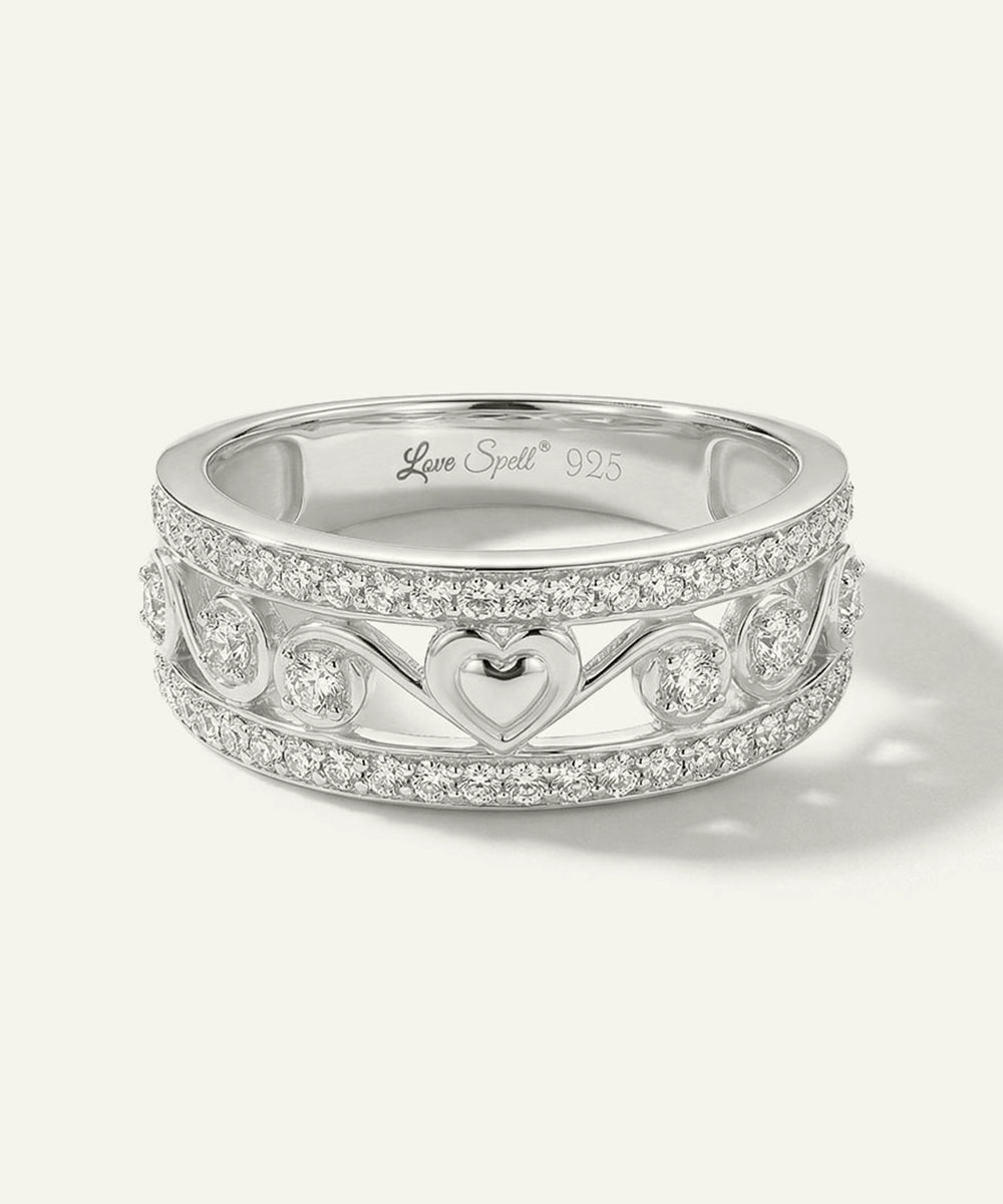Silver ring with heart design and 'Love Spell' branding on a white background