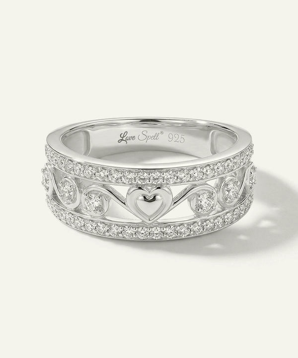 Silver ring with heart design and 'Love Spell' branding on a white background