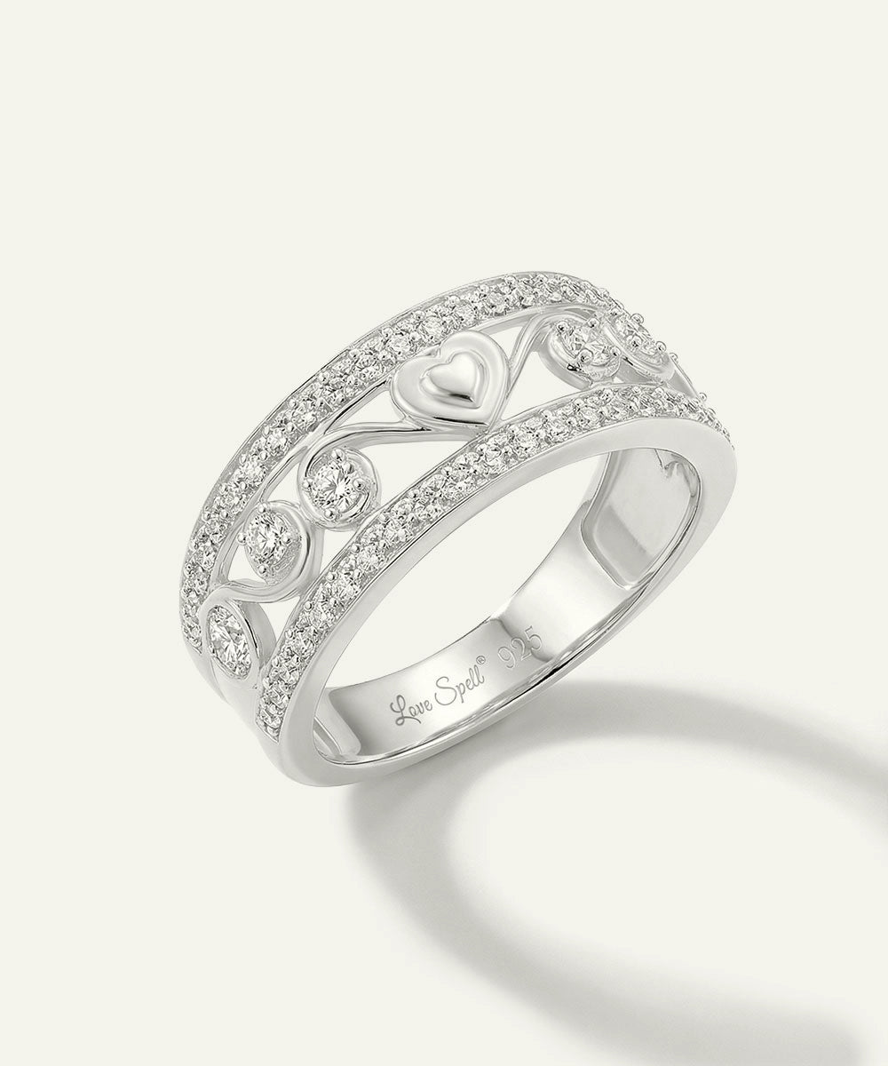 Silver ring with intricate design and diamonds on a white background