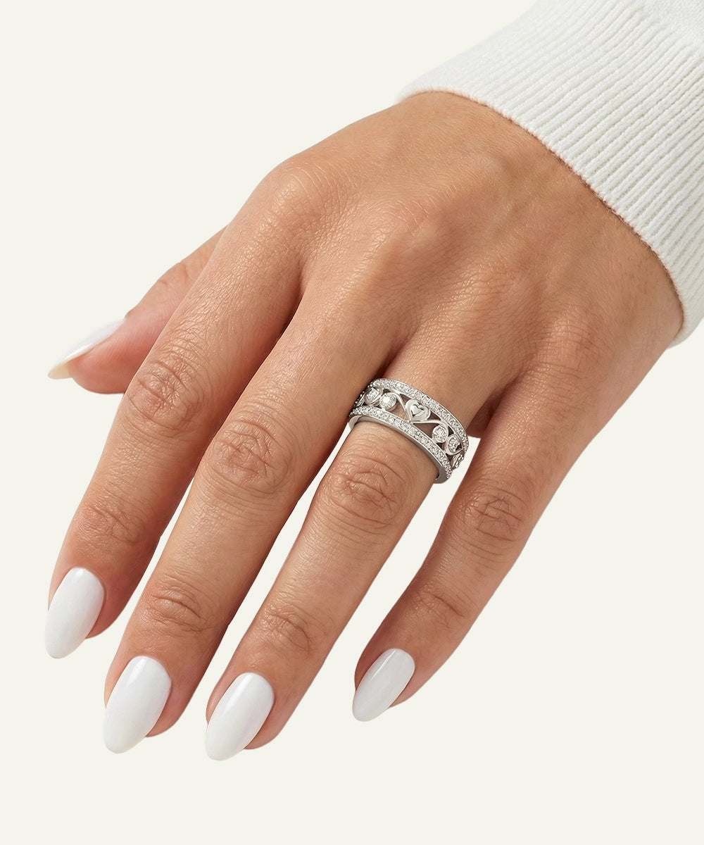 Hand wearing a silver ring with a white background