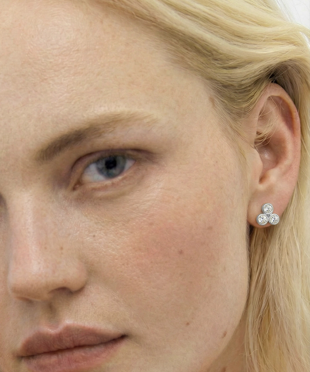 Close-up of a person wearing a three-stone earring.