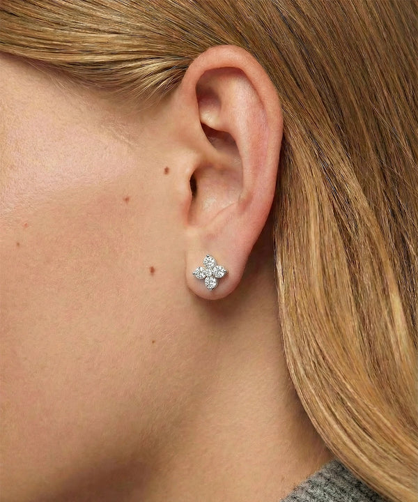 Close-up of a person wearing a diamond earring.