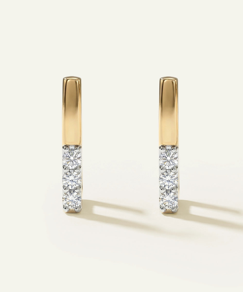 Gold and diamond earrings on a white background