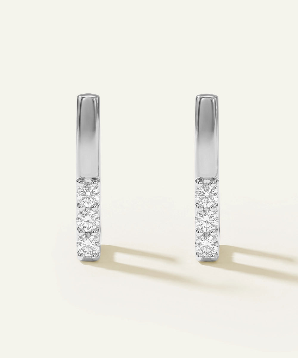 Pair of diamond earrings on a light gray background
