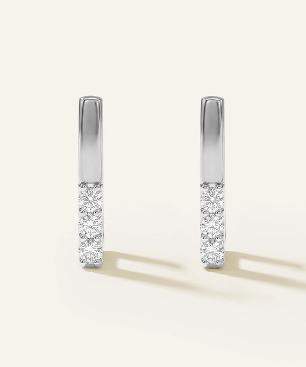 Pair of diamond earrings on a light gray background