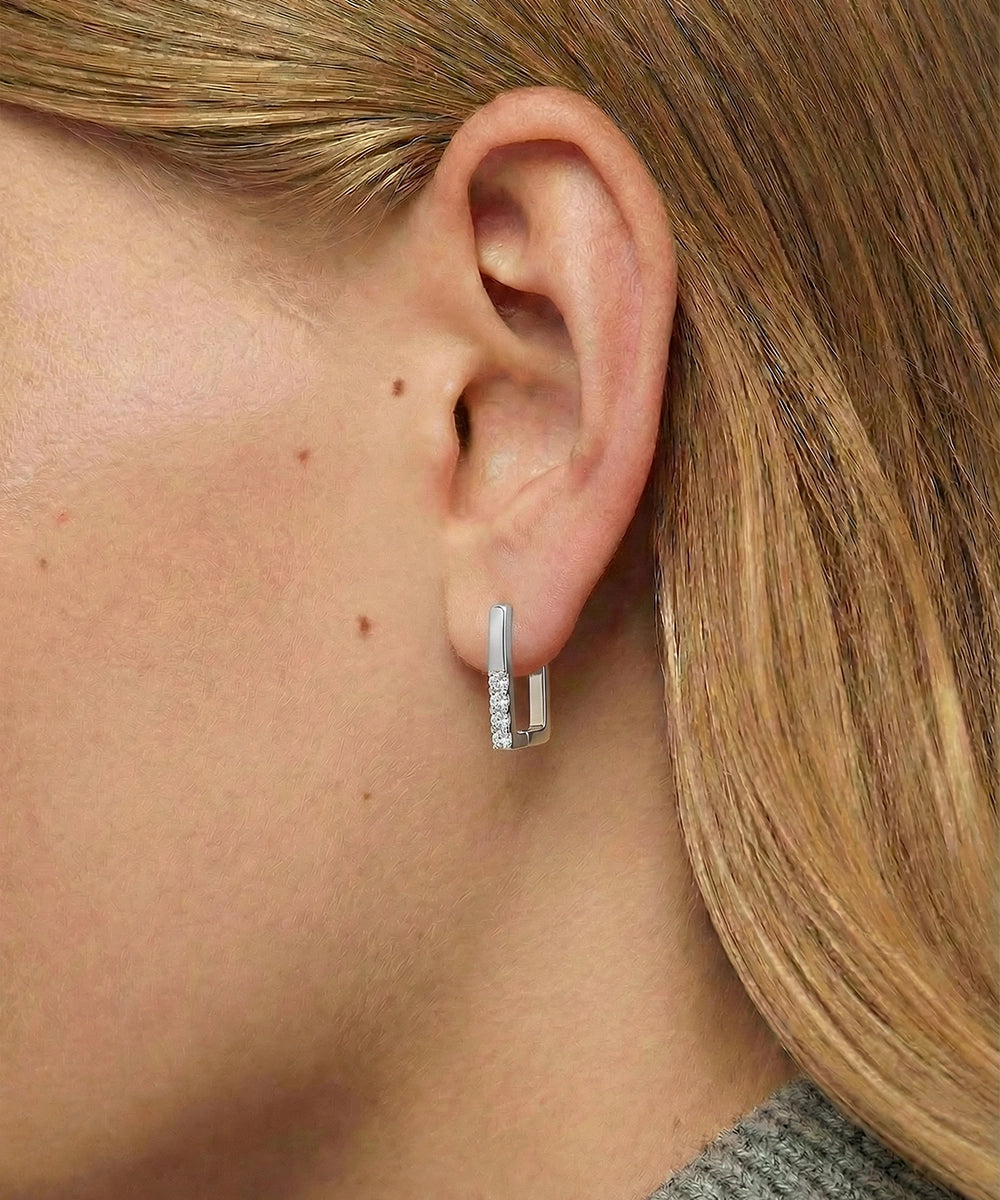Silver hoop earrings worn by a person with blonde hair.
