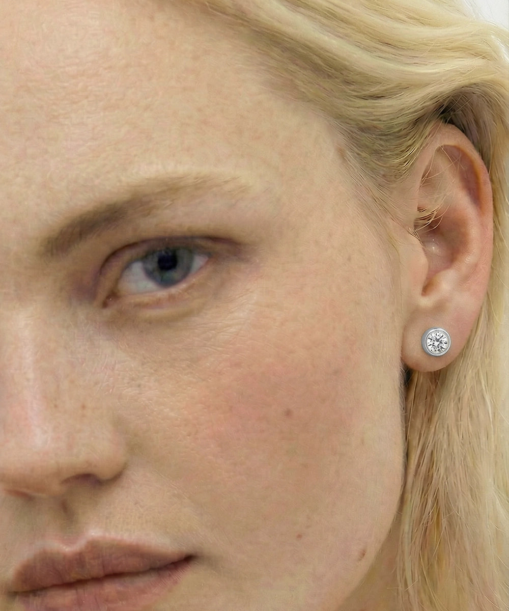 Close-up of a woman wearing a diamond stud earring.