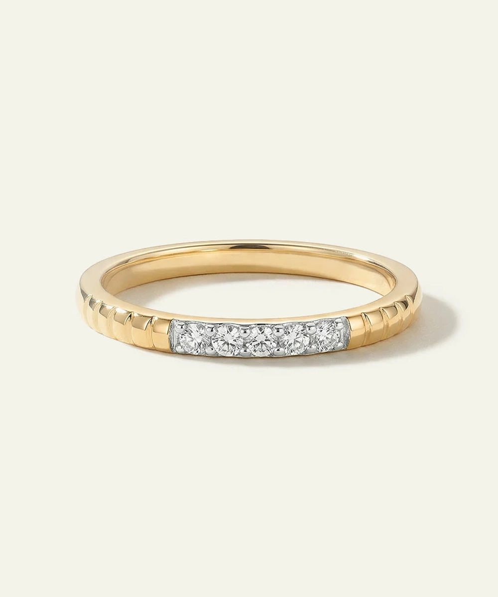 Gold ring with embedded diamonds on a white background