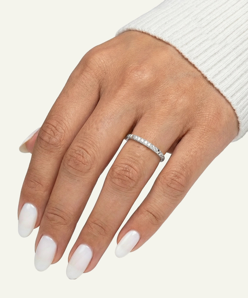 Hand wearing a silver ring with a diamond on a white background