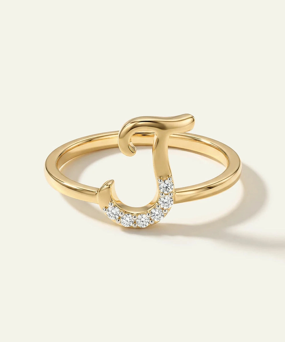 Gold ring with a horseshoe design on a light beige background