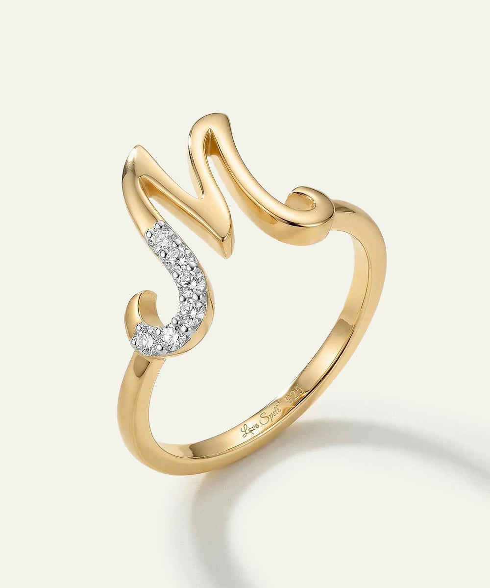 Gold ring with diamond accents on a light gray background