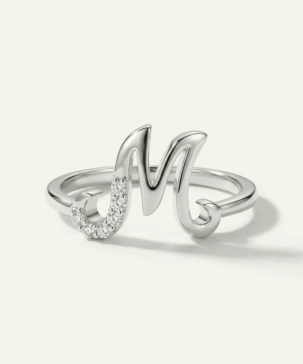 Silver ring with a letter 'M' design on a white background