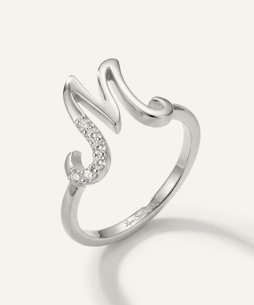 Silver ring with diamond accents on a light gray background