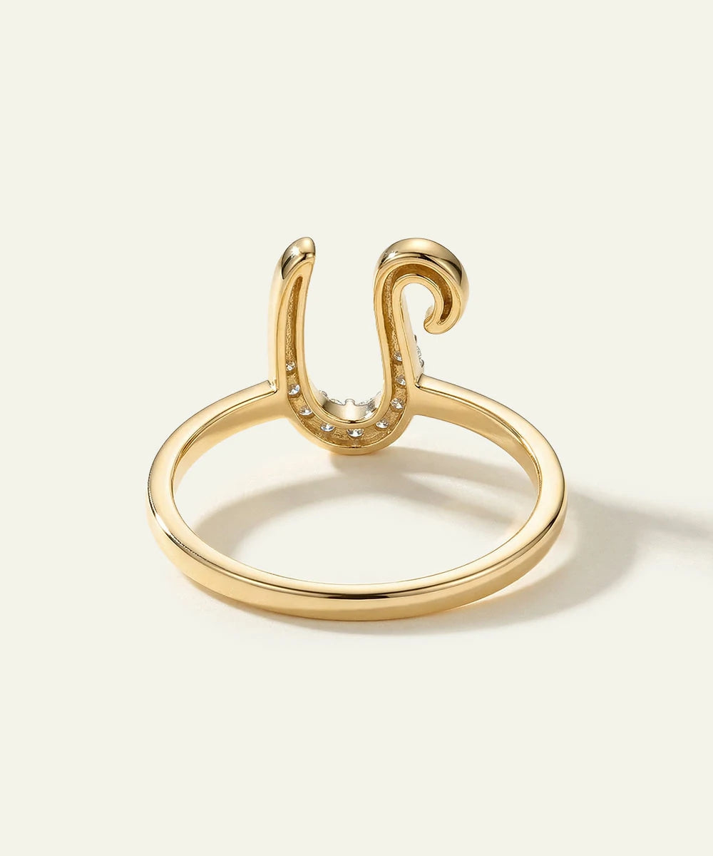 Gold ring with a unique design on a light beige background