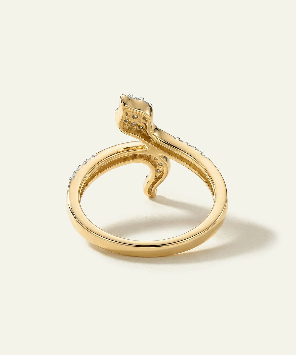 Gold ring with a snake design on a light background