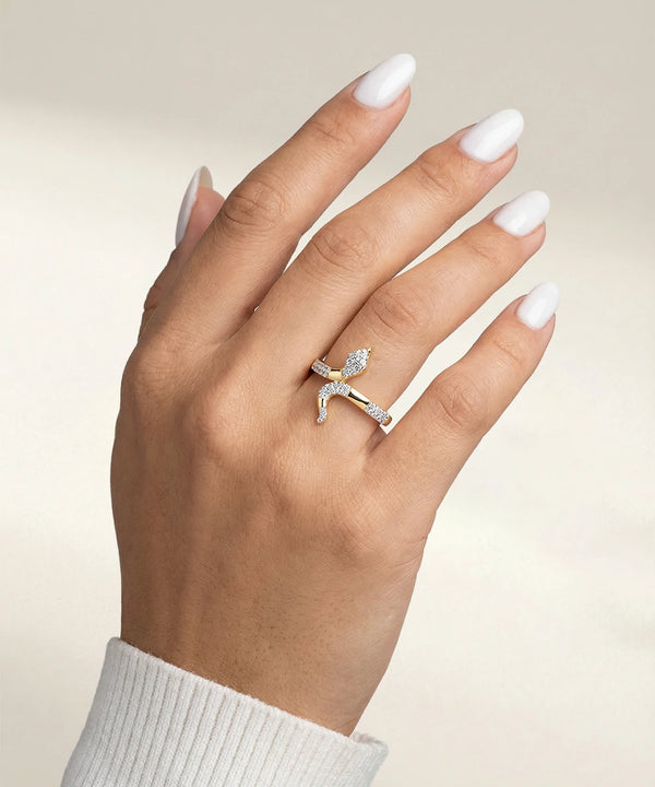 Hand wearing a silver ring with a diamond on a beige background