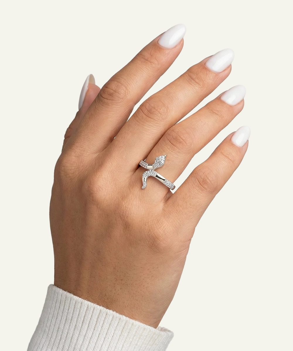 Hand wearing a silver ring with a small diamond on a light background