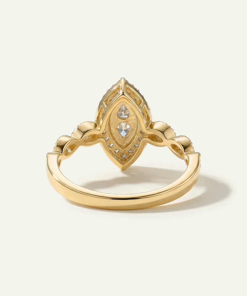 Gold ring with intricate design on a light beige background