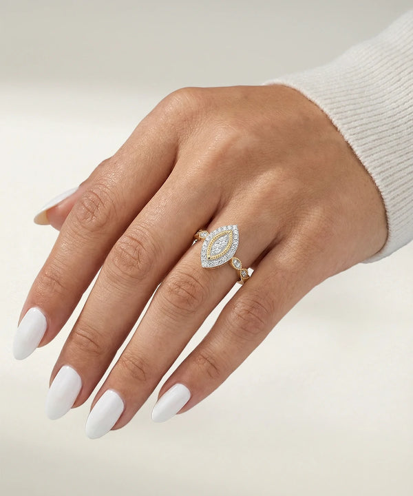 Hand wearing a diamond ring on a neutral background