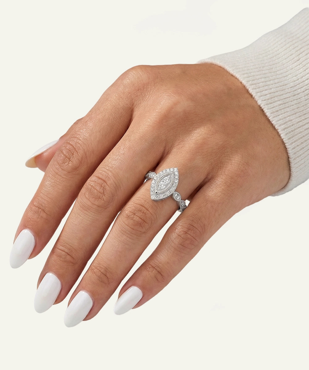 Hand wearing a silver ring with a diamond on a white background