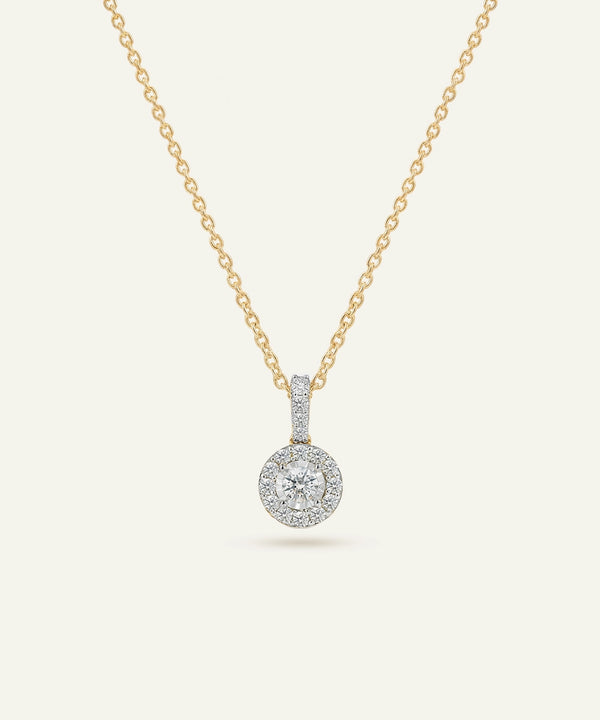Gold necklace with a diamond pendant on a white background