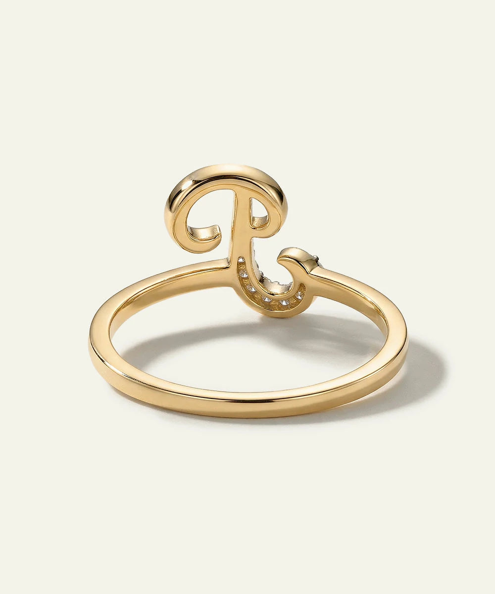 Gold ring with a decorative design on a light beige background